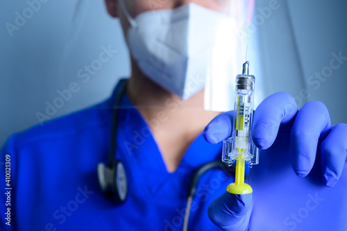 male healthcare worker preparing to administer an anticoagulant injection