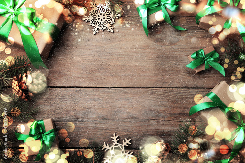 Frame of gift boxes and Christmas decorations on wooden table, flat lay. Space for text