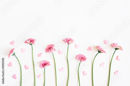Valentine's Day background. Pink flowers, hearts on white background. Valentines day concept. Flat lay, top view, copy space