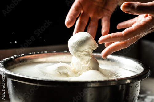 The homemade cheese maker produces handmade mozzarella with fresh bio milk. process of making mozzarella. Italian hard cheese silano or caciocavallo in cheesemaker hands