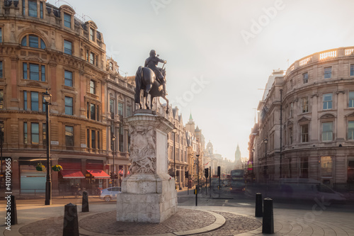 A view of the Equestrian Statue of Charles I from Trafalgar Square in Central London city, England UK as golden light crests the building tops.