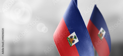 Small national flags of the Haiti on a light blurry background