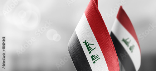 Small national flags of the Iraq on a light blurry background