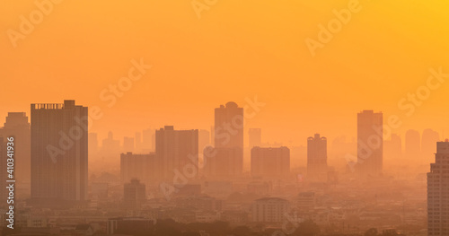 Air pollution. Smog and fine dust of pm2.5 covered city in the morning with orange sunrise sky. Cityscape with polluted air. Dirty environment. Urban toxic dust. Unhealthy air. Urban unhealthy living.