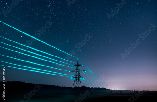 Electricity transmission towers with glowing wires against the starry sky. Energy concept.