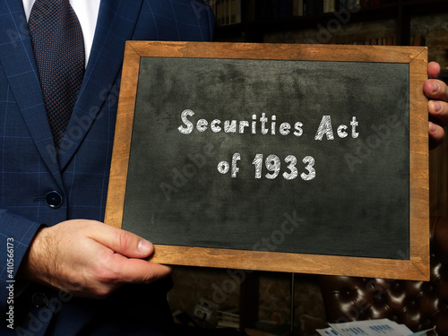 Young man holding a card in hands. Conceptual photo about Securities Act of 1933 with written text.