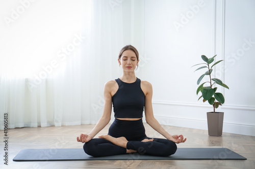 Young woman practicing lotus asana in yoga studio. Padmasana pose