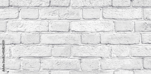 White shabby brick wall close-up wide texture. Light grey rough old brickwork widescreen background
