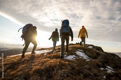 Hikers with backpacks walks in mountains at sunset