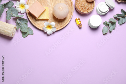 Flat lay composition with salt and cosmetic products on violet background. Space for text