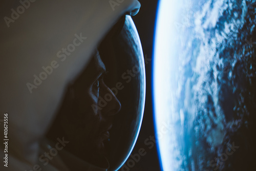 Astronaut looking deep space, galaxy and planets from the window of his capsule. Concept about science and space exploration