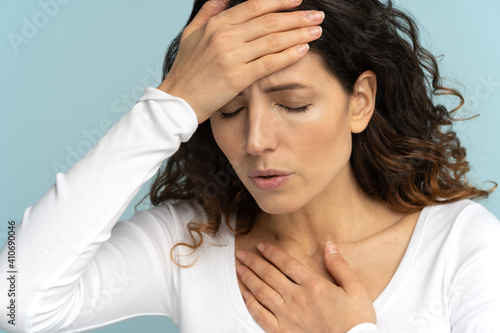 Breathing, respiratory problem, asthma attack, pressure, chest pain, sun stroke, dyspnea concept. Studio portrait of woman received heatstroke in hot summer weather, touching her forehead, isolated