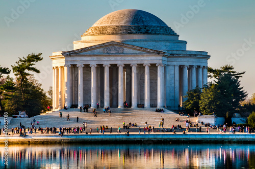 spring morning sunlight illuminating Thomas Jefferson Memorial in Washington DC with crowd of people on the steps.