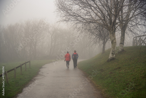 dos mujeres paseando por el monte en un día con niebla 