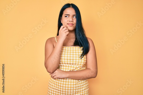Young beautiful asian girl wearing casual clothes serious face thinking about question with hand on chin, thoughtful about confusing idea