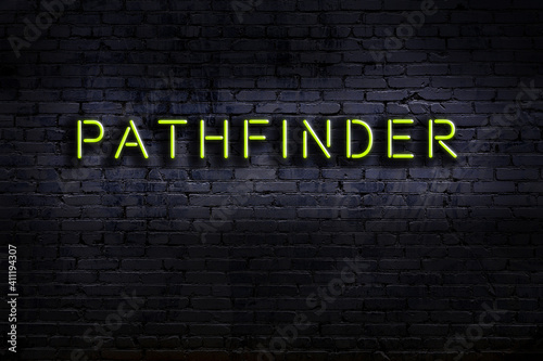 Neon sign. Word pathfinder against brick wall. Night view
