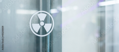 Radiation zone sign sticker on window of laboratory room. Health and safety concept