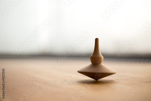 wooden Spinning top in action on wooden flor, rotating totem in motion