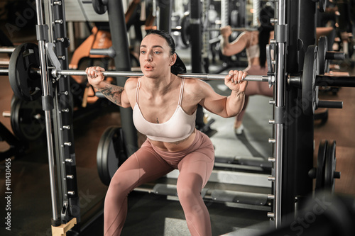 Young beautiful caucasian fit strong woman is doing exercises in gym