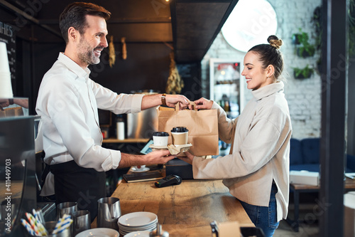 Female customer take away shopping at cafe buying coffee and food