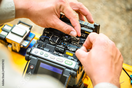 Fiber Optic Fusion Splicing Cable checking signal and Wire connection with Fiber Optic Fusion Splicing machine.The technician is checking the fiber optic cable