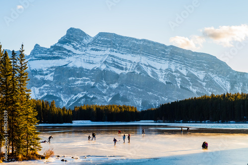 Beautiful view of people ice-skating on the Two Jack Lake in Banff national park, Canada