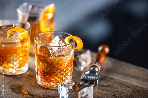 Old fashioned rum drink on ice with orange zest garnish