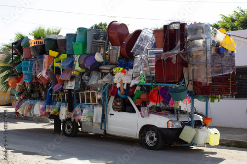 Vendedor ambulante latino mexicano vehículo comercio informal negocio emprendedor comerciante portátil colorido escobas utensilios tianguis mercado tienda rodante