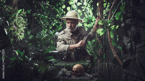 Brave explorer walking in the jungle with a machete