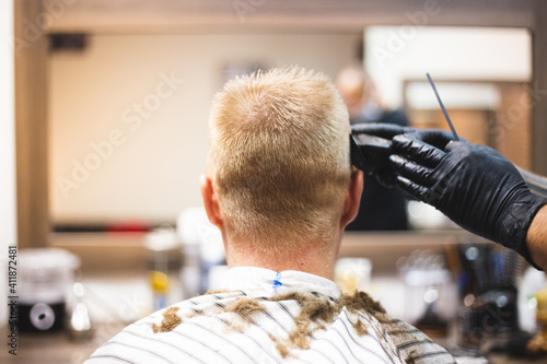 Męskie cięcie włosów mężczyzna od tyłu u barbera bez twarzy