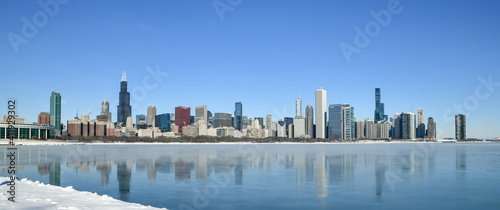 Big city skyline along frozen lakeshore in winter