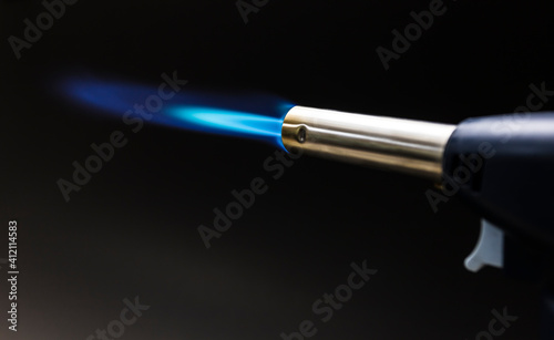 Blue flame from a gas torch burner on black background
