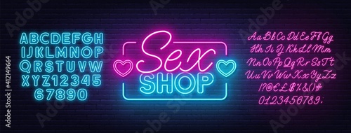 Sex Shop neon sign on brick wall background. Pink and blue neon alphabets.