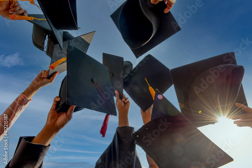 Graduates throwing graduation hats Up in the sky