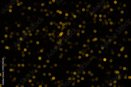 Yellow bokeh on a black background. Glare to decorate the photo.