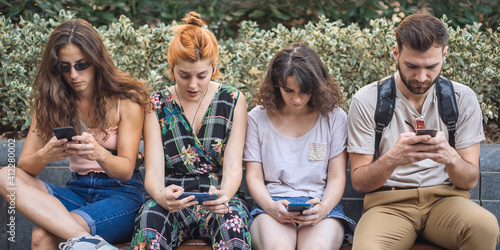 Alienation addiction. Group of friends using smartphones together. Young people addiction to new technology trends. Youth, new generation internet friendship concept. Emotional isolation and depresion