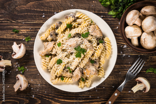 Pasta fusilli with Chicken and mushrooms In cream sauce. Top view on wooden table.