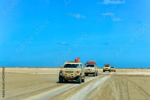 Convoy of muddy campers on a desert on a sunny day