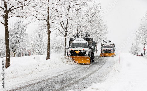 snow plowing machine in suburban neighborhood during northeastern storm nor'easter