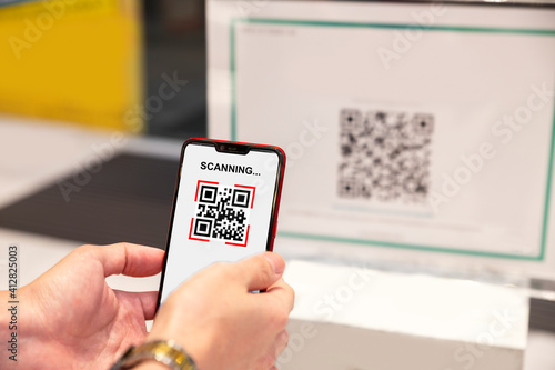 Qr code payment, E wallet , cashless technology concept. Man scanning tag before access inside the office building.