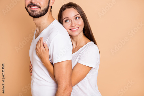 Cropped photo of pretty adorable husband wife wear white t-shirts embracing smiling isolated beige color background