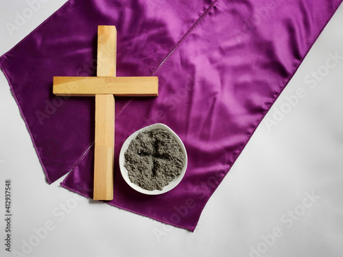 Lent Season,Holy Week and Good Friday concepts - photo of wooden cross and bowl of ash in vintage background. Stock photo. 