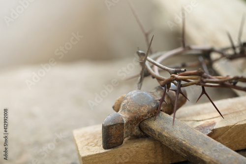 Crown of thorns, wooden plank and hammer on grey background, closeup. Easter attributes