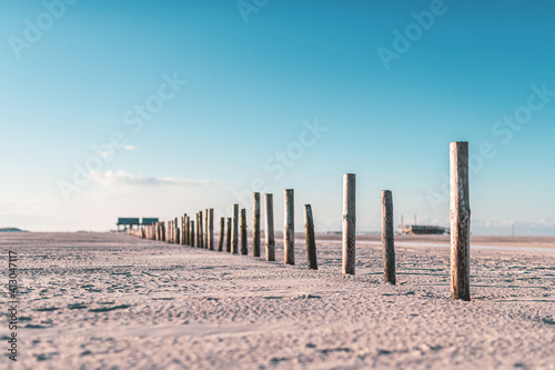 Pfähle am Strand von Sankt-Peter Ording bei Sonnenschein