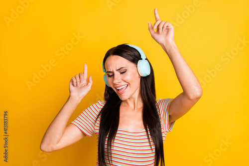 Photo portrait of pretty woman in headphones enjoying music singing song isolated on vibrant yellow color background