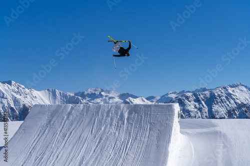 Skier performing an inverted trick in a snowpark in Austria on a sunny day