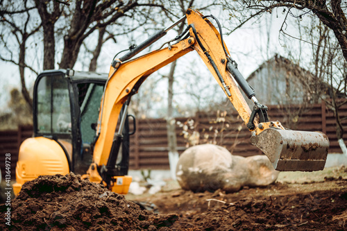 Landscaping works with mini excavator at home construction site. Terrain works