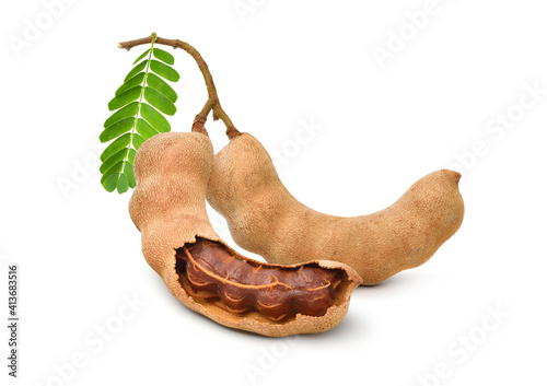 Tamarind fruits with green leaves isolated on white background.