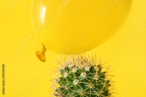 Cactus and air balloon on color background