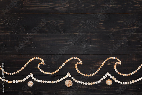 Waves from seashells on wooden background